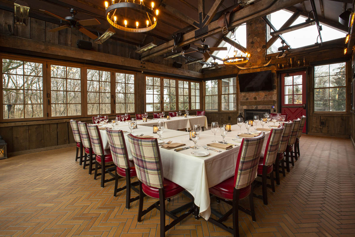 Interior of the Trophy Room at The Barn with empty tables and chairs set up for an event.