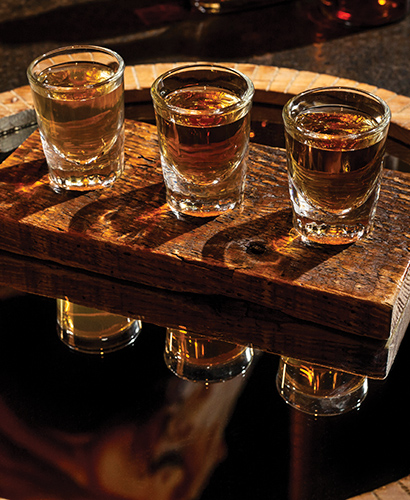 Trio of bourbons in tasting glasses presented in wood holder