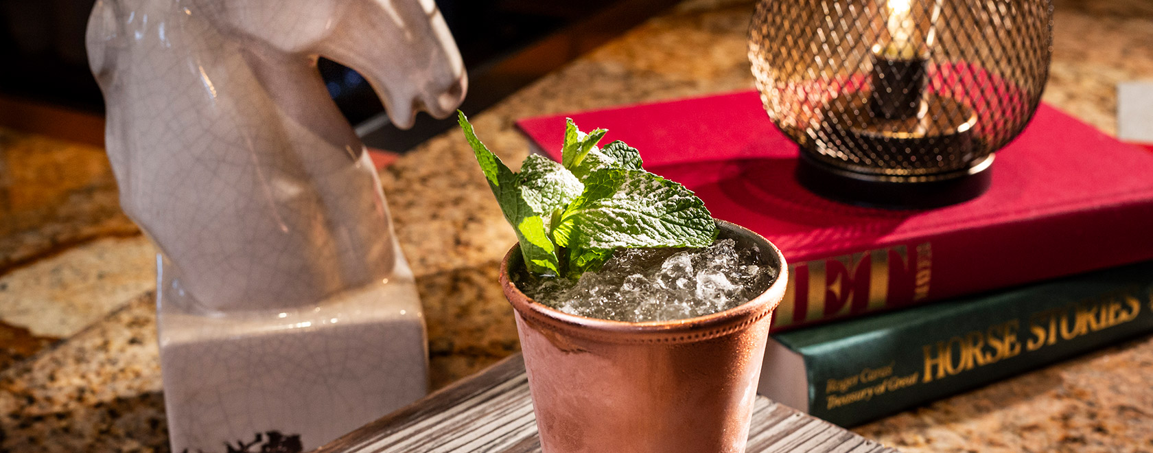 Icy mint julep in frosty copper cup with mint sprig garnish